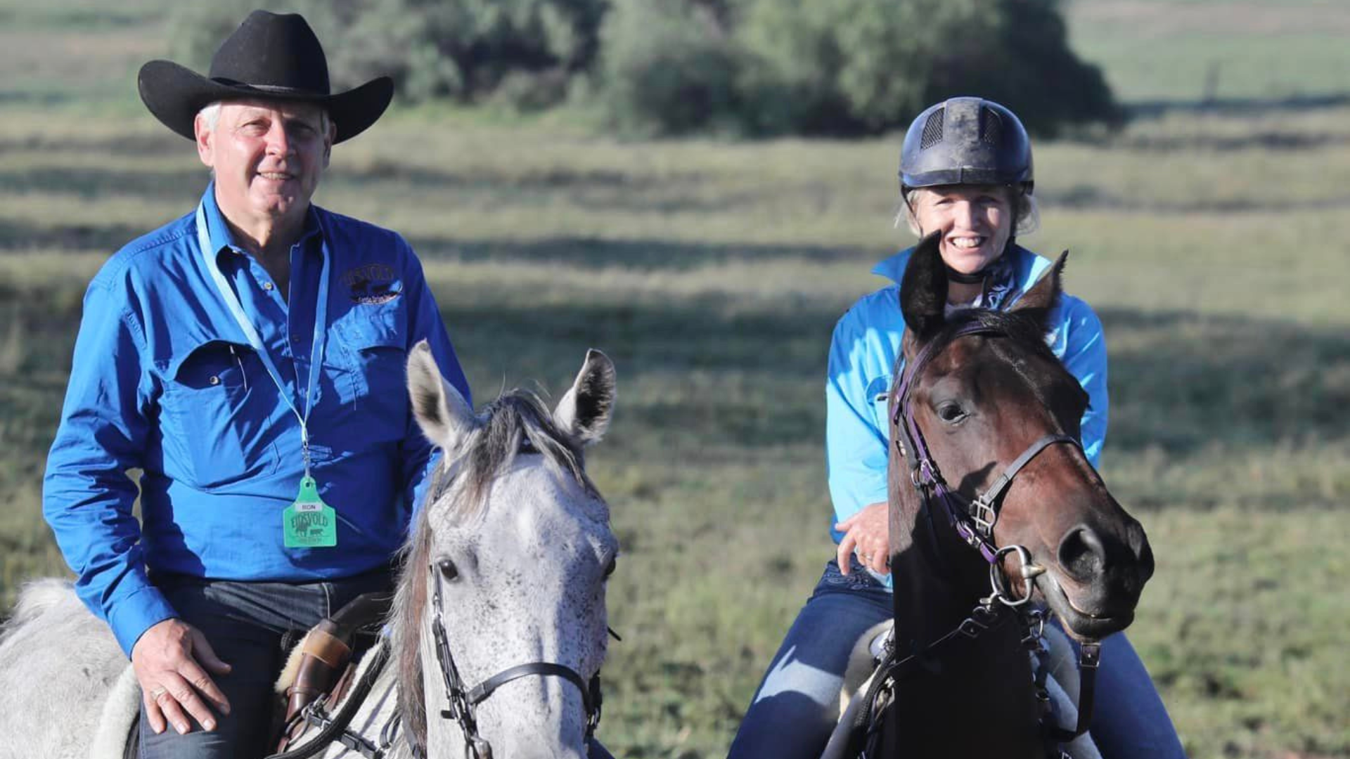 A man and a woman riding their horses.